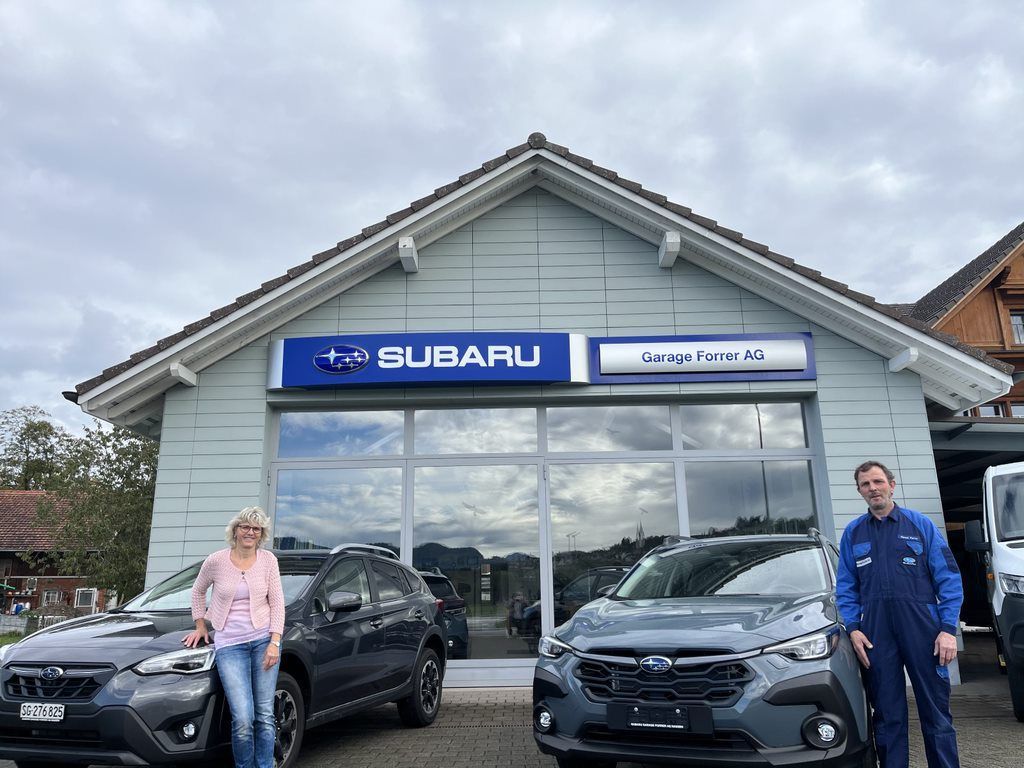 Ein Mann arbeitet in einer Garage an der Unterseite eines Autos.