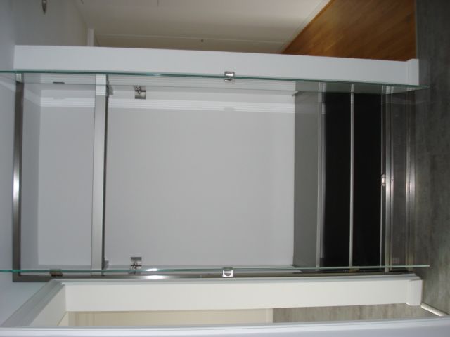Offener Glas- und Metallschrank mit Schiebetüren in einer modernen Küchennische