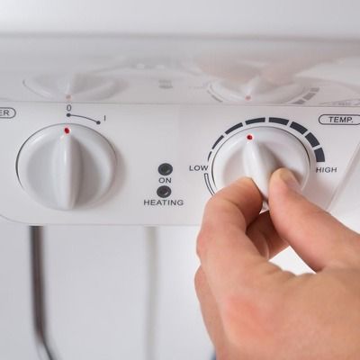 Una persona está ajustando la temperatura de un calentador.