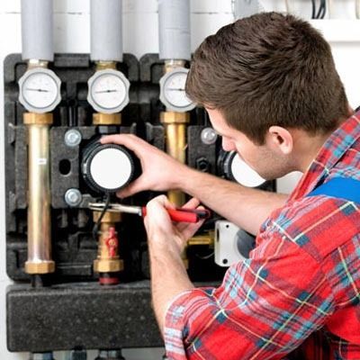 Un hombre con una camisa a cuadros está trabajando en una máquina.
