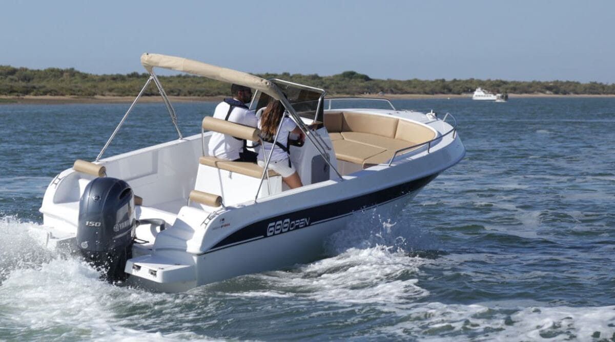 Un barco blanco flota sobre un cuerpo de agua.