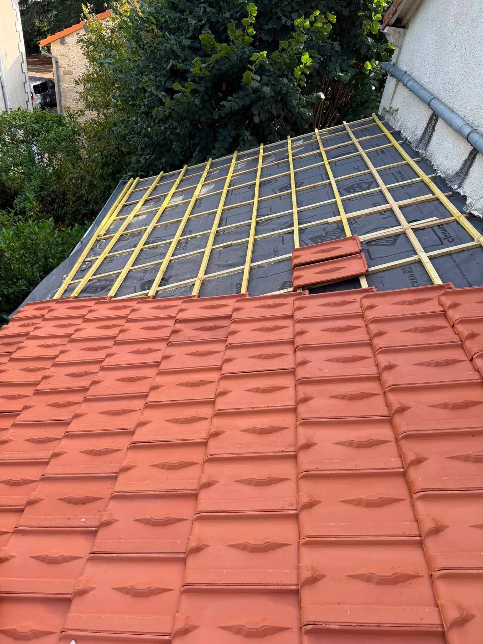 Toiture en tuiles de terre cuite avec un câble blanc diagonal sur un toit en pente