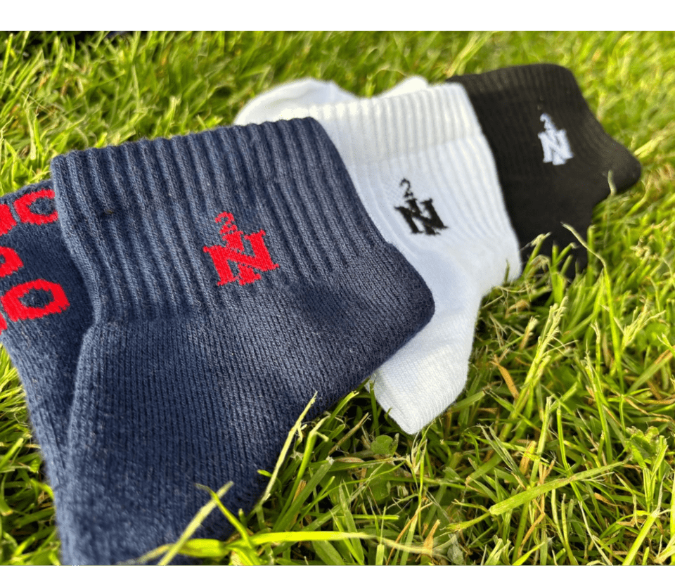 Drei Paar Socken liegen im Gras.