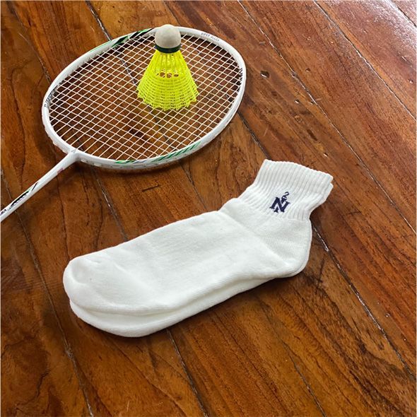 Ein Paar weiße Socken und ein Badmintonschläger
