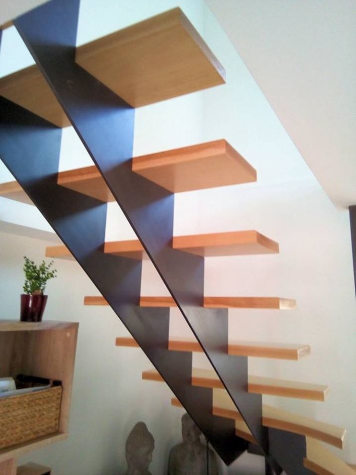 Pose d'un escalier en acier et en bois dans un intérieur de maison