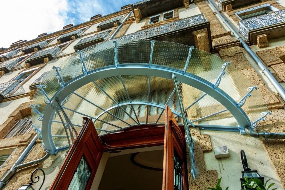 Une marquise fixée devant une porte d'entrée