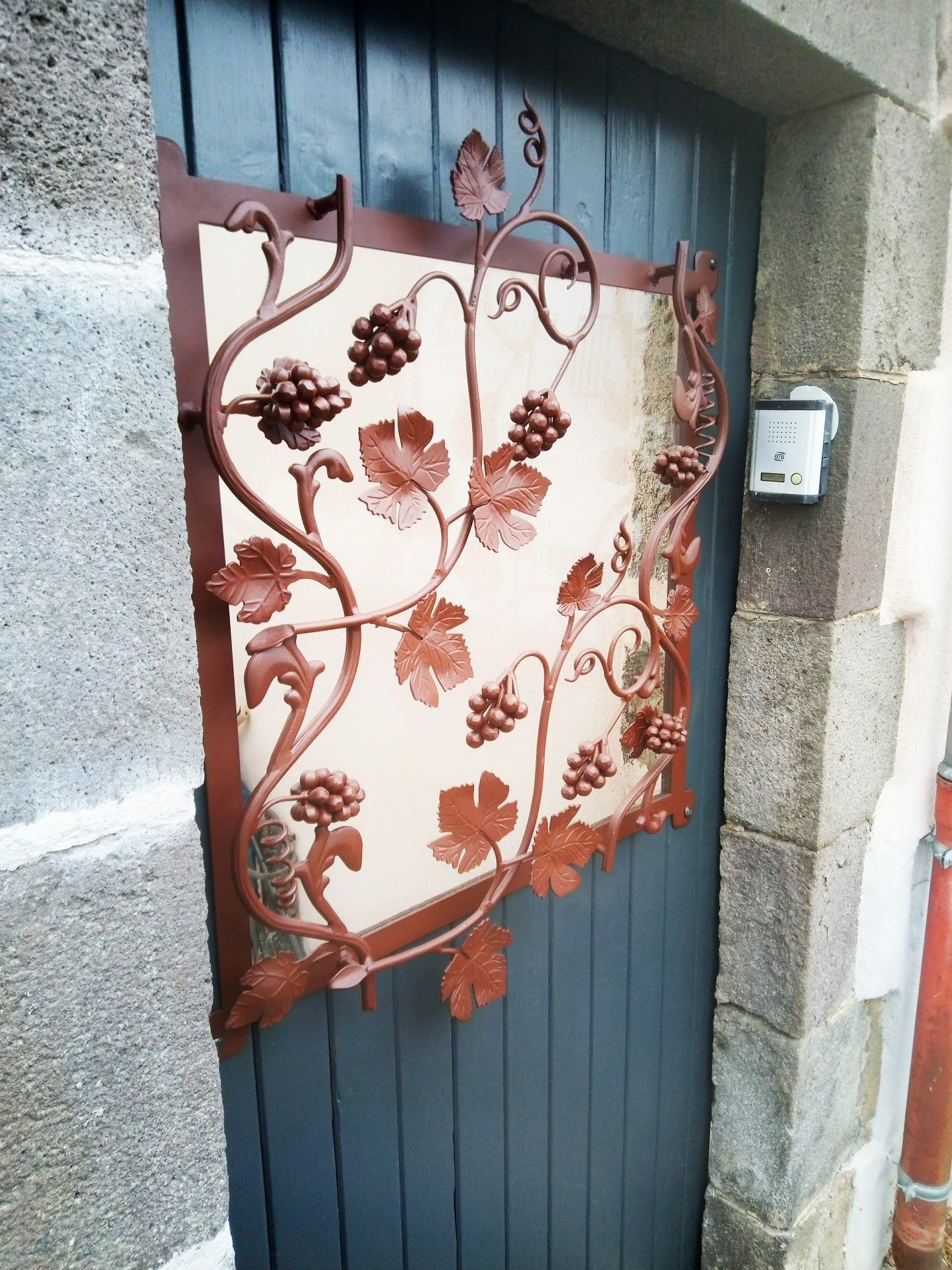 Une grille de défense fixée à une porte d'entrée pour sécuriser le logement