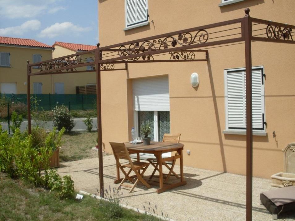 Une pergola en acier sur la terrasse d'une maison neuve