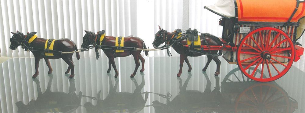Carruaje negro tirado por caballos con ruedas rojas sobre un fondo blanco.