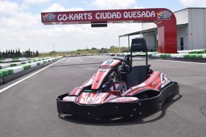 Un kart rojo y negro está estacionado en una pista de carreras.