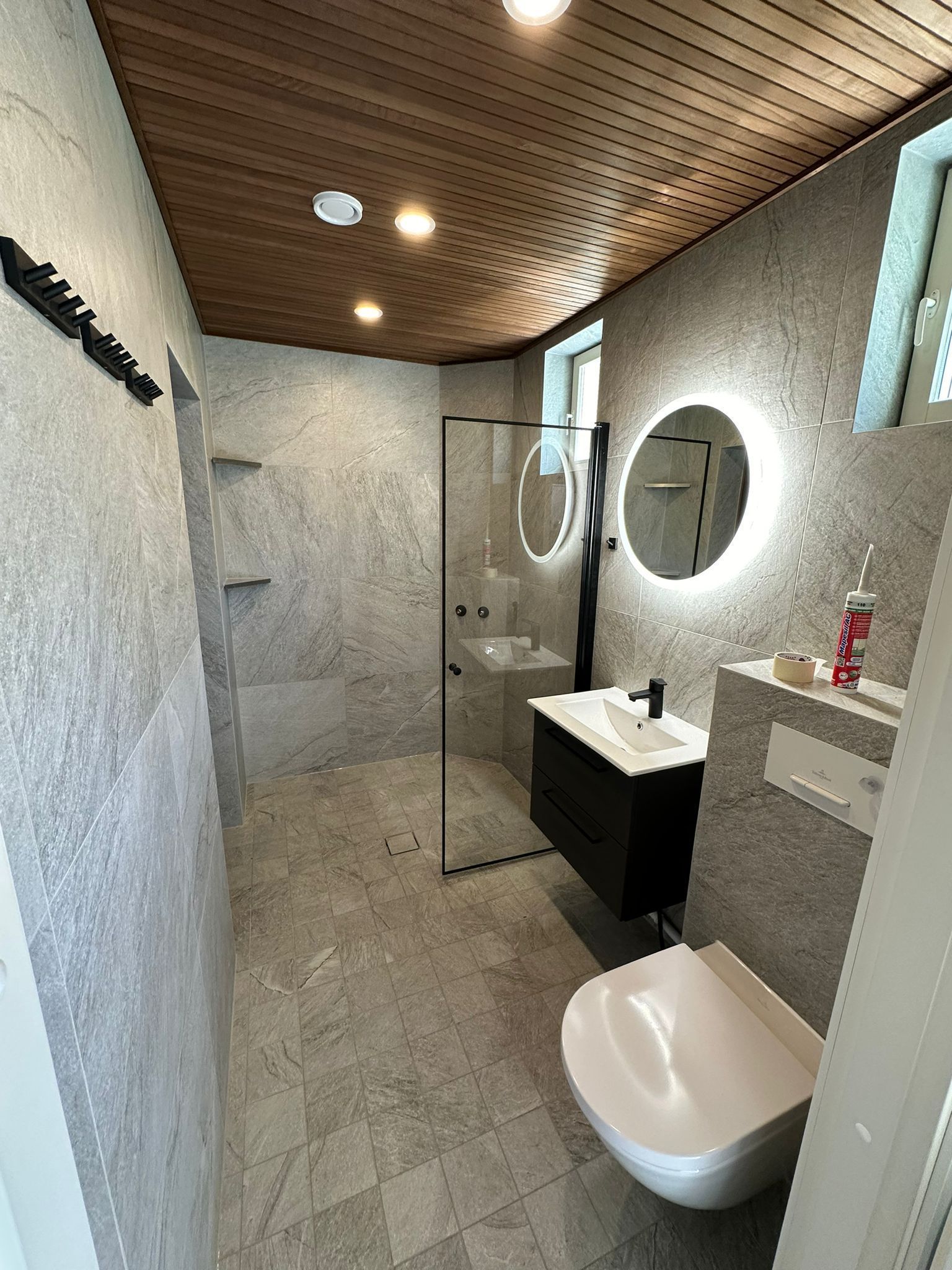 Moderni suihkutila harmaa laatoitus ja lasiseinä kylpyhuoneremontti Renomen.