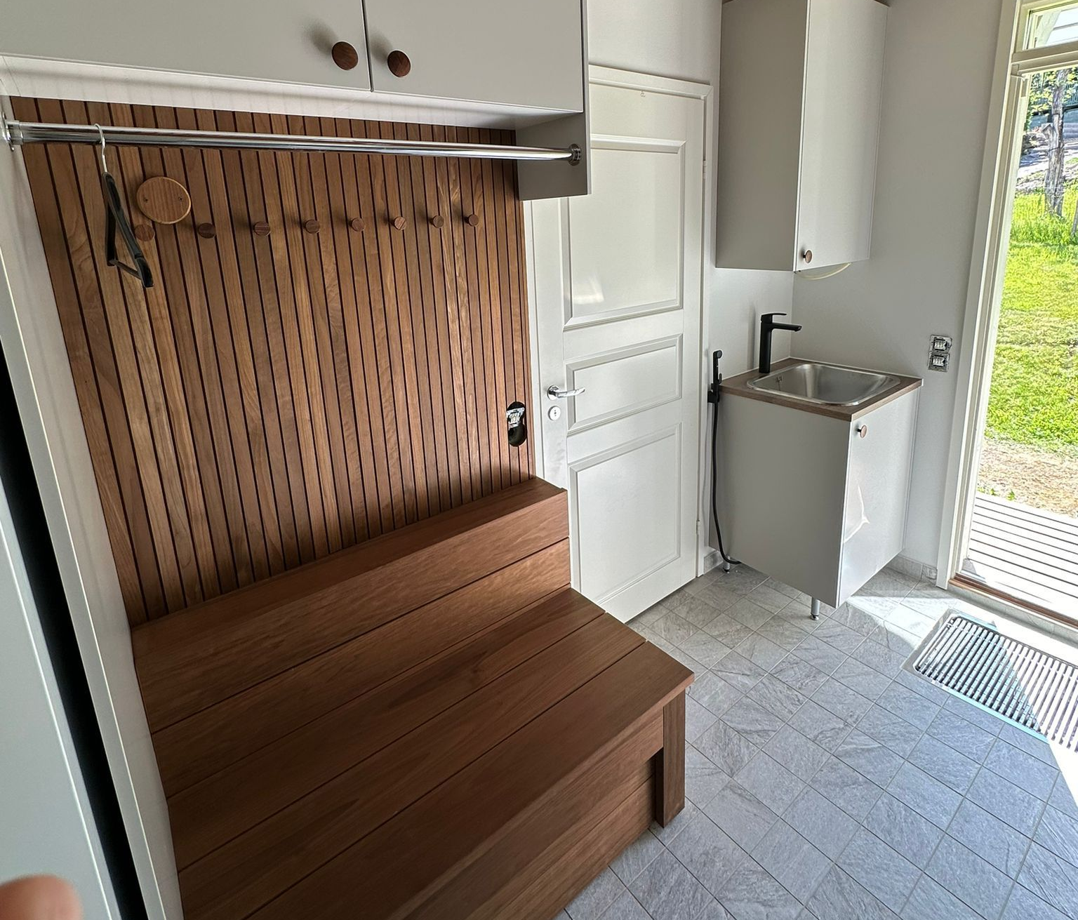 Renomen Oy huoneistoremontti Uusimaa – moderni kodinhoitohuone ja eteistila vaaleilla pinnoilla.