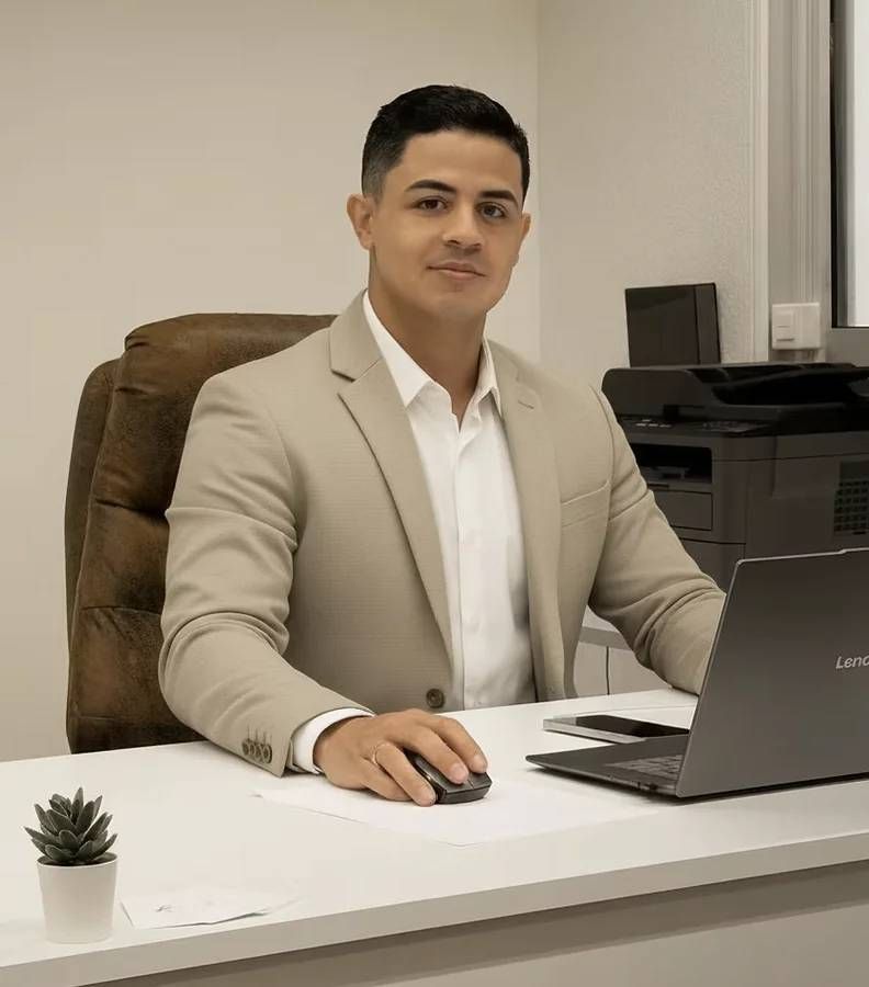 Eine Person blättert an einem Schreibtisch neben einem Laptop und Diagrammen in Dokumenten.
