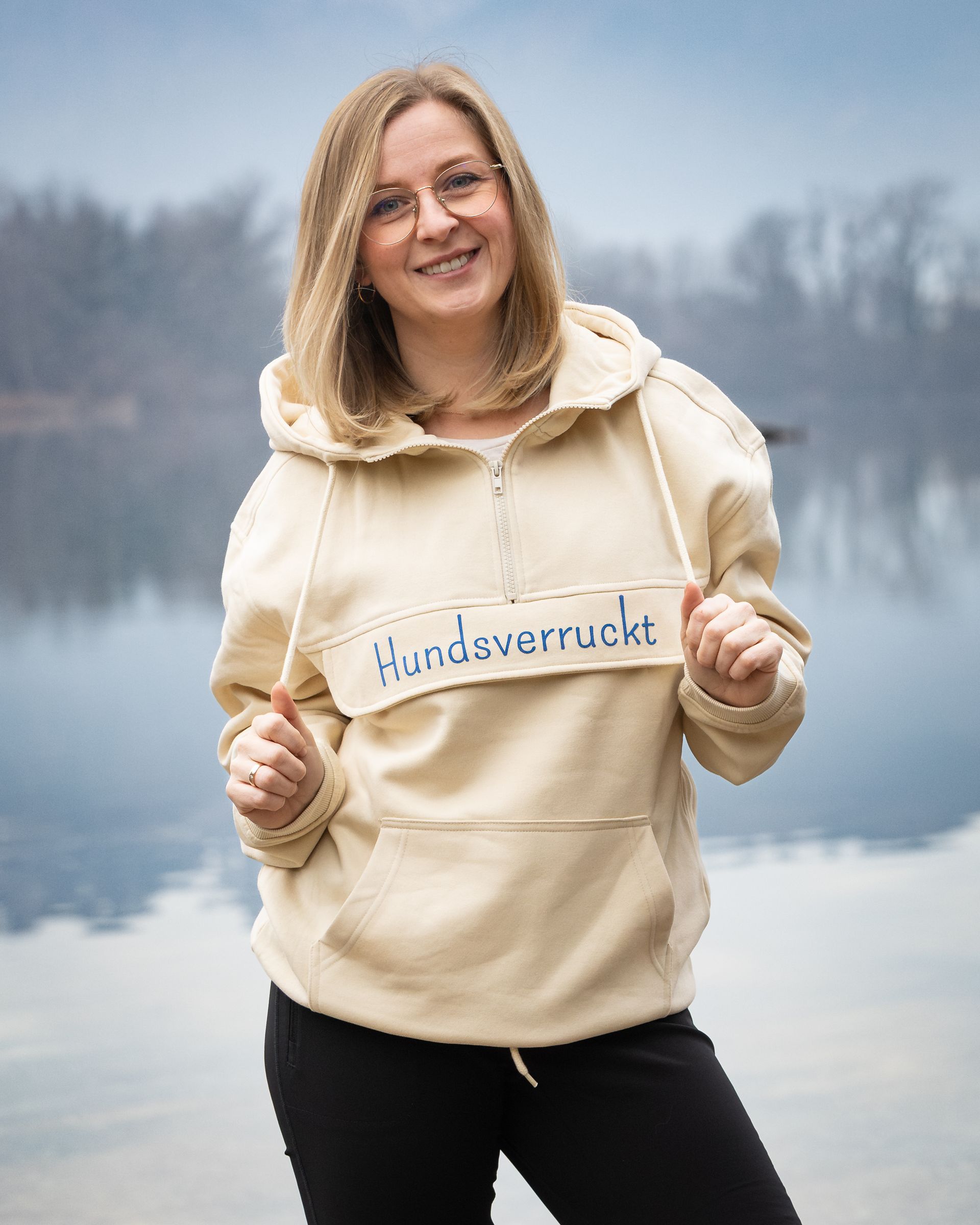 Frau trägt Hoodie mit Hunde-Motiv am See – nachhaltige Hundemode bei Hundsverruckt, dem Hundenladen