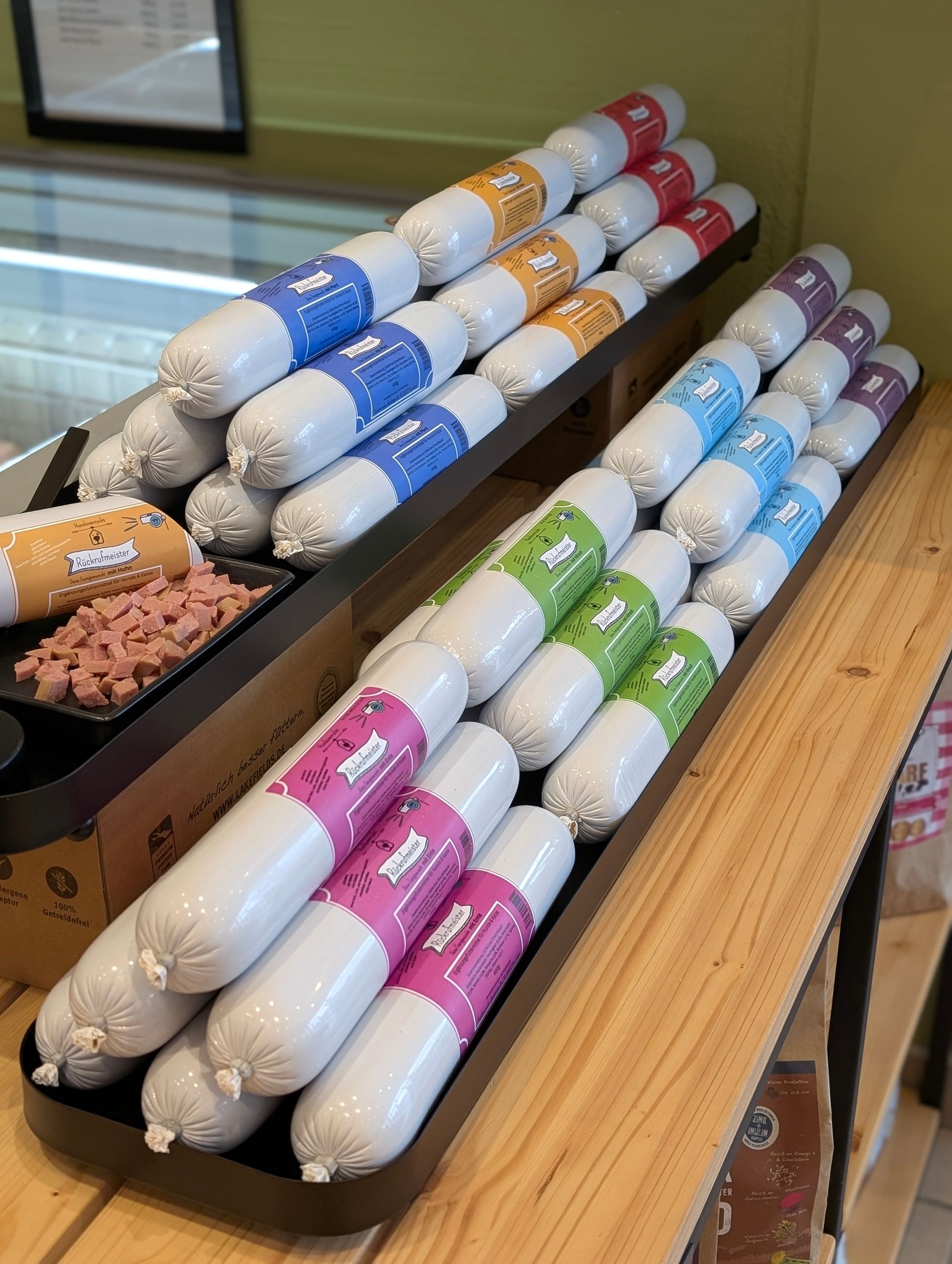 Verschiedene Sorten Hunde-Wurst und Snacks im Regal – natürliche Ernährung bei Hundsverruckt Hundenladen