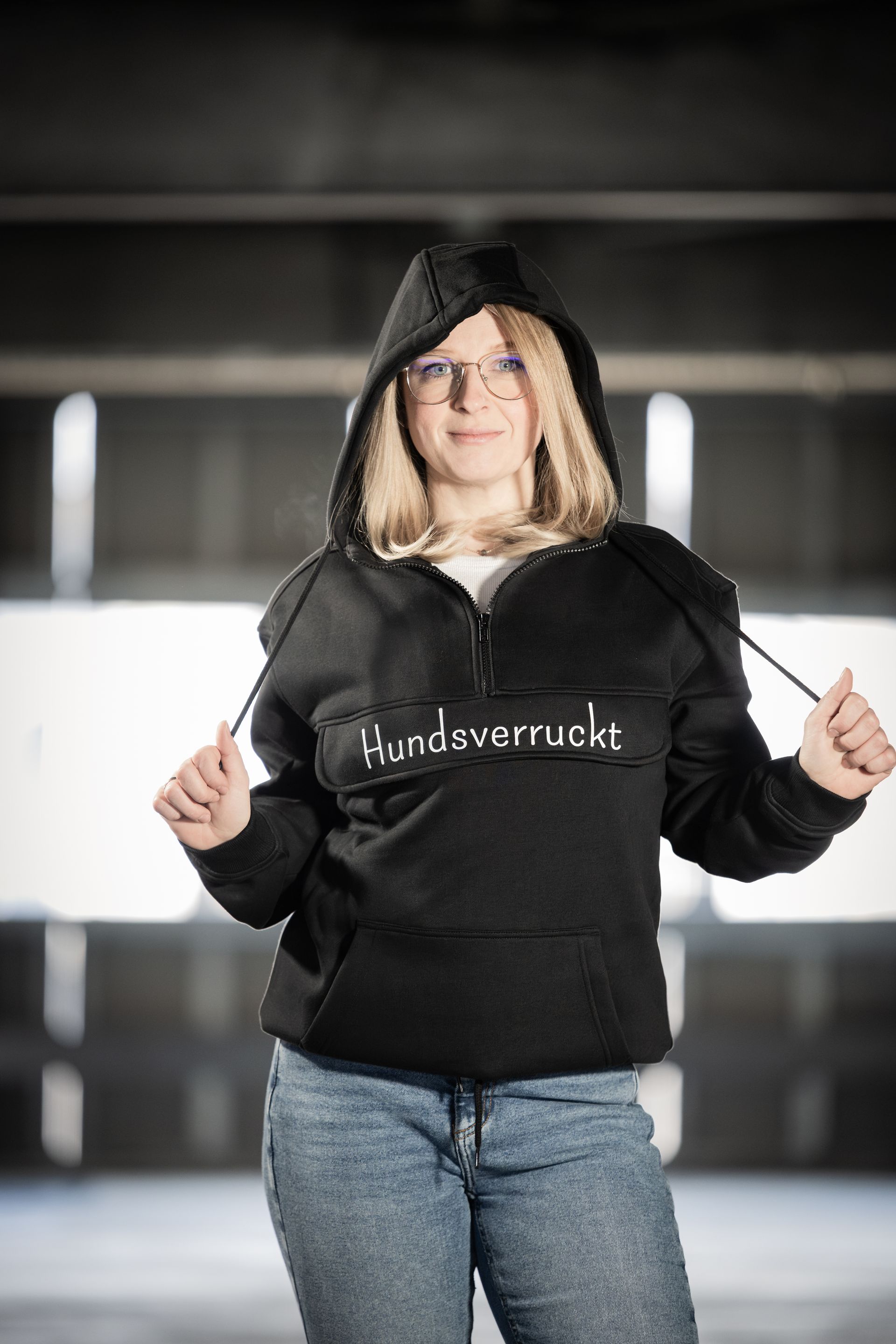 Frau trägt ein schwarzes Hoodie mit Hunde-Motiv am See – nachhaltige Hundemode bei Hundsverruckt, dem Hundenladen