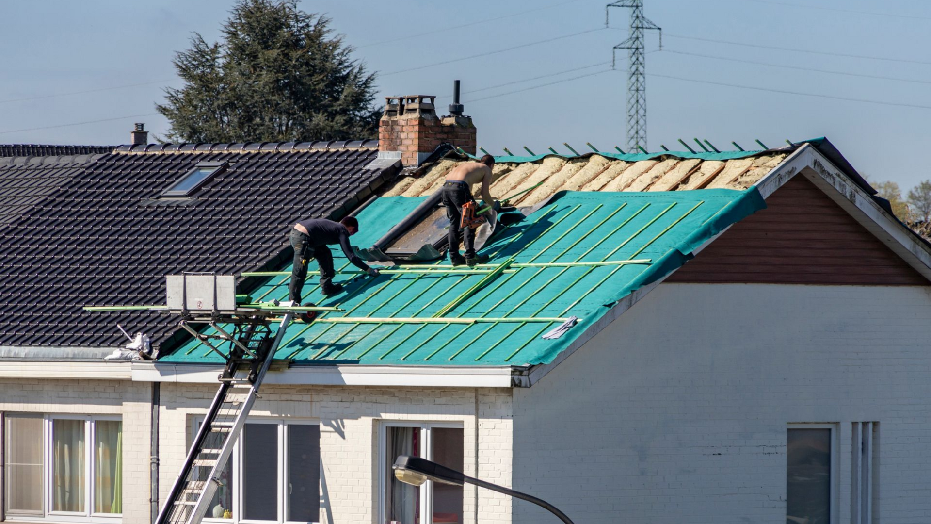 Des ouvriers refont la toiture d'une maison : pose du pare-pluie