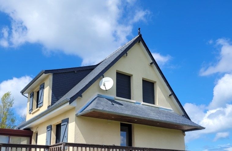 Maison couleur crème avec toit foncé et antenne parabolique