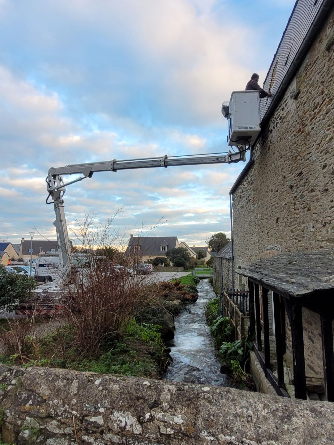 Une longue nacelle élévatrice s'étend depuis un bâtiment en pierre