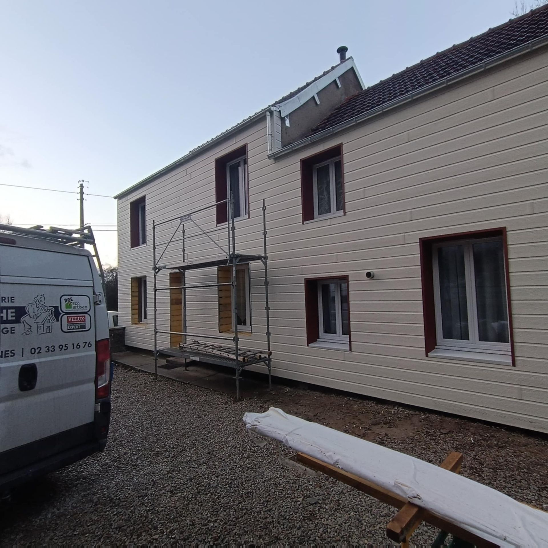 Extérieur d'une maison avec des échafaudages et un camion de chantier