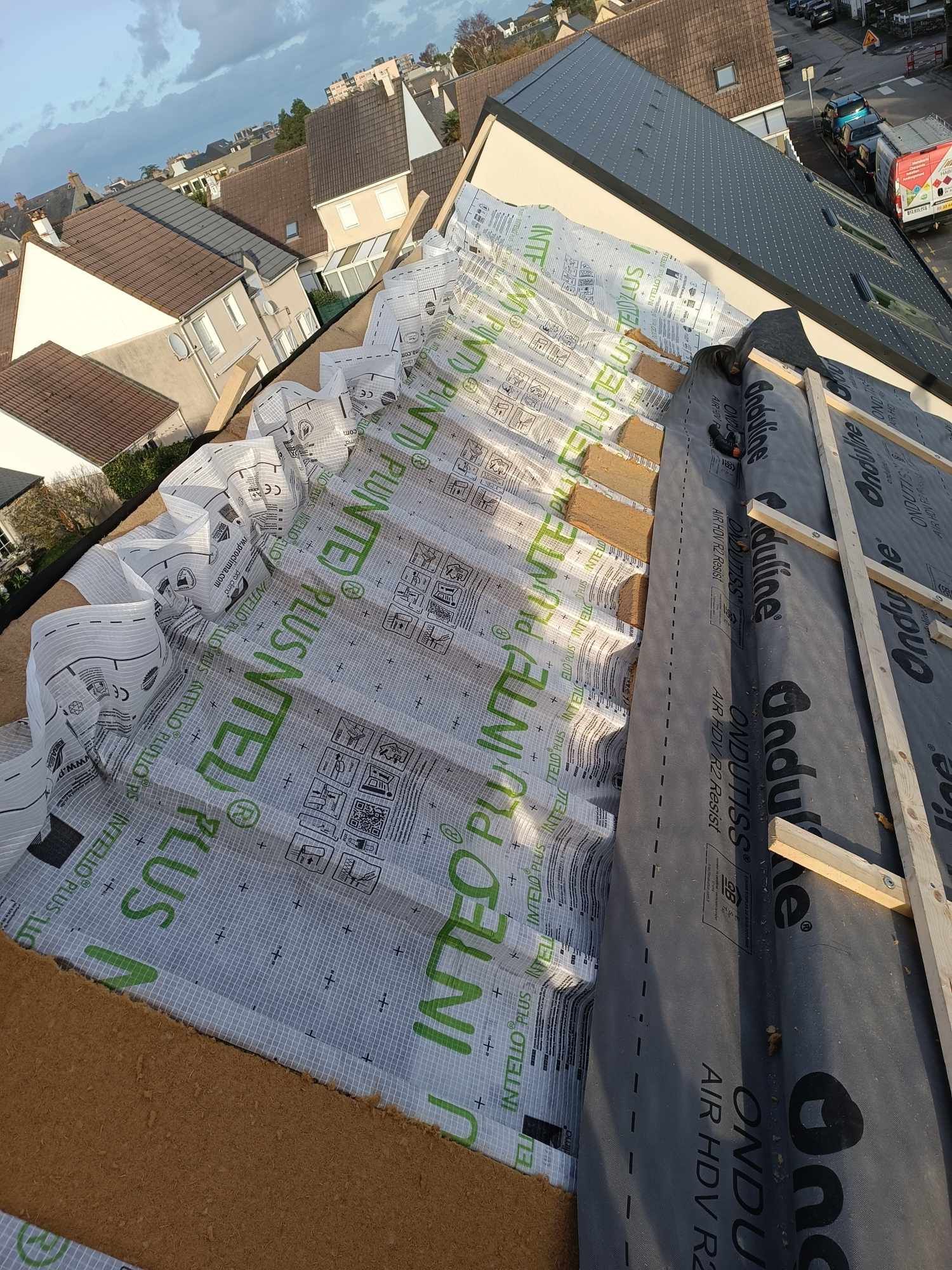 Toiture en cours d'isolation avec membrane d'étanchéité et liteaux en bois