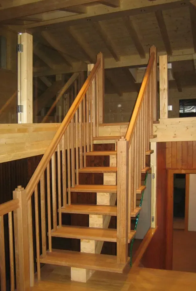Escalier en bois avec rampe menant à une mezzanine dans un intérieur rustique