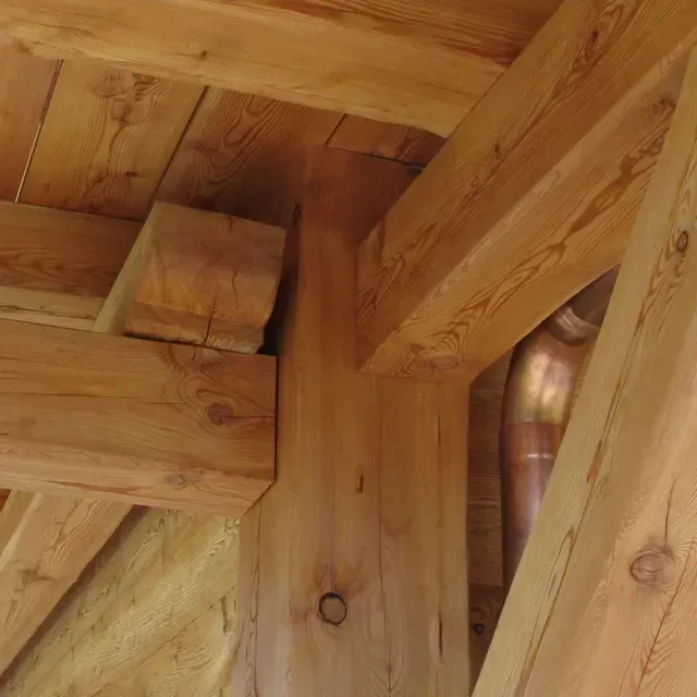 Gros plan sur des poutres et des planches en bois dans une structure rustique en colombages