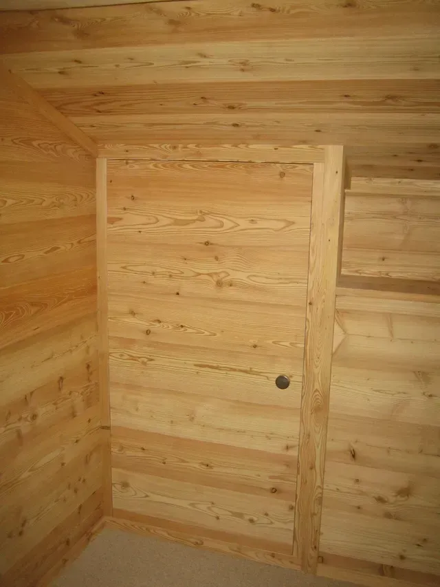 Coin intérieur en bois avec une porte simple et des panneaux horizontaux