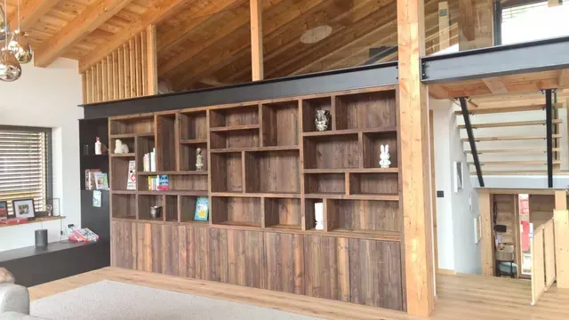 Intérieur de loft moderne avec de grandes étagères encastrées en bois, des poutres apparentes .