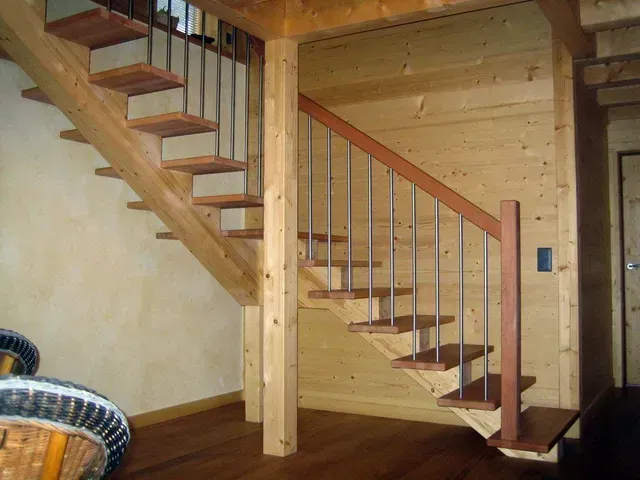 Escalier intérieur en bois avec rampe dans un intérieur de cabane rustique