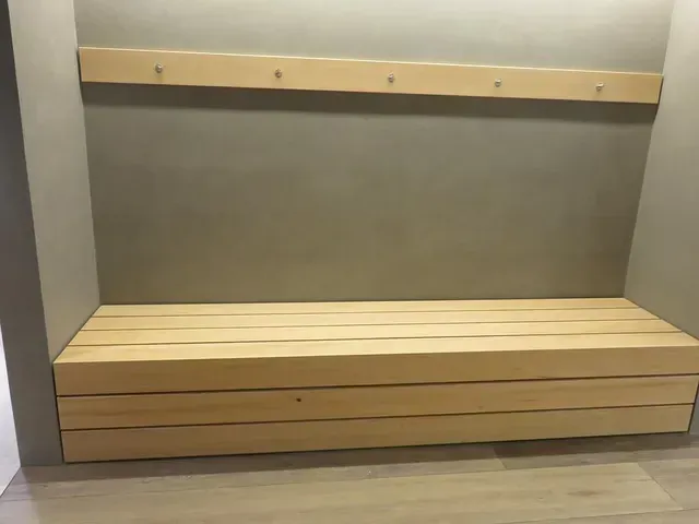 Banquette encastrée en bois vide avec étagère dans une alcôve grise