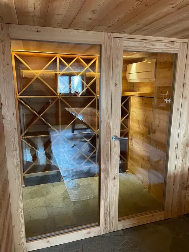 Porte de cave à vin en bois vitrée avec étagères visibles à l'intérieur