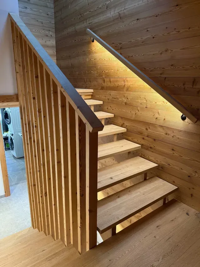 Escalier intérieur en bois avec contremarches ouvertes, rampes verticales