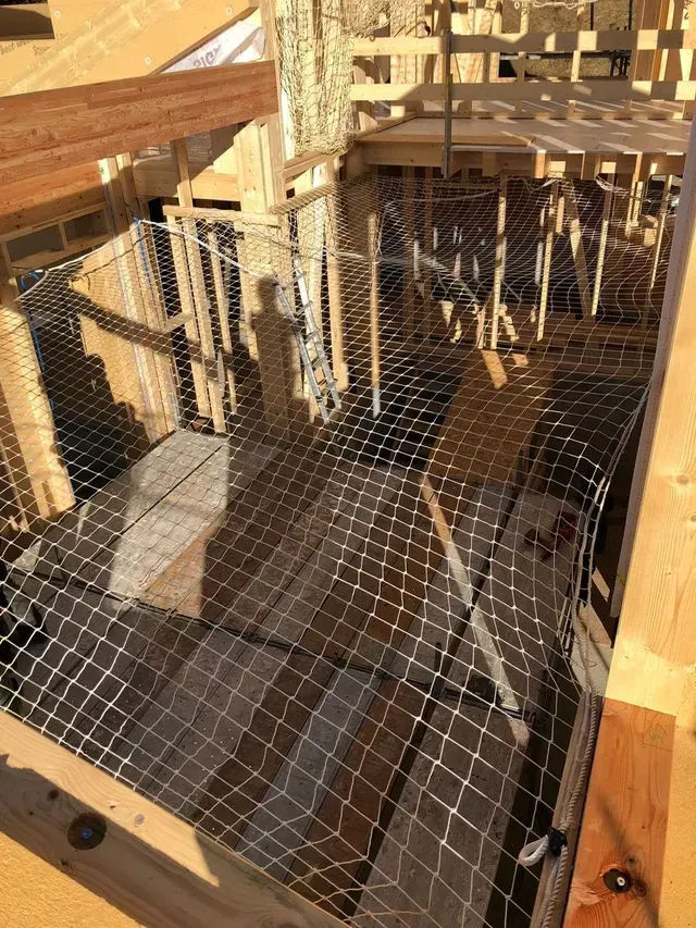 Terrasse en bois en construction avec rambardes métalliques et plancher en treillis métallique sous un soleil éclatant