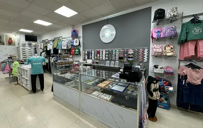 Una mujer está parada frente a una vitrina en una tienda de ropa.