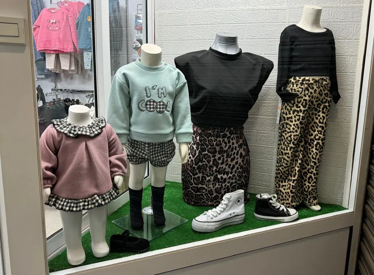 Una exhibición de ropa infantil en el escaparate de una tienda.