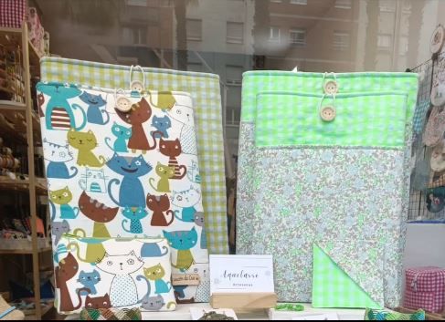 Dos bolsas con gatos están expuestas en el escaparate de una tienda.