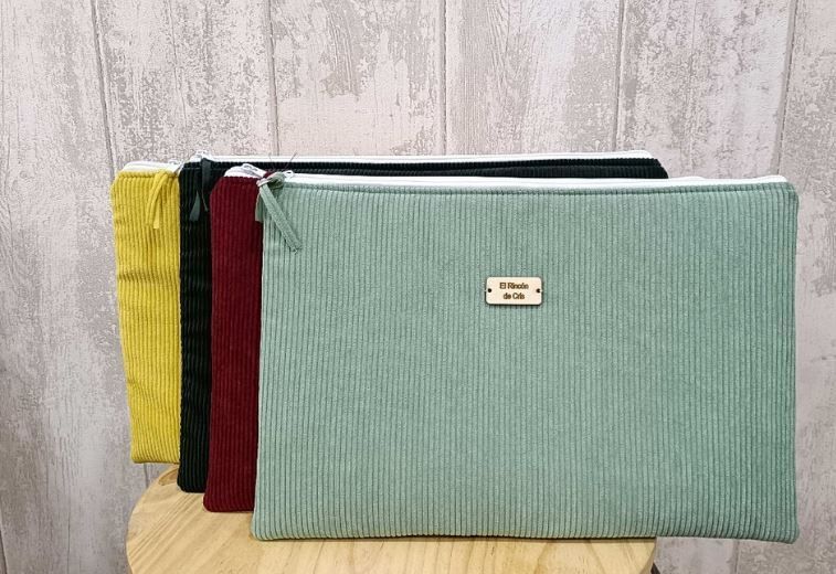 Un grupo de bolsos de mano están apilados uno encima del otro sobre una mesa de madera.