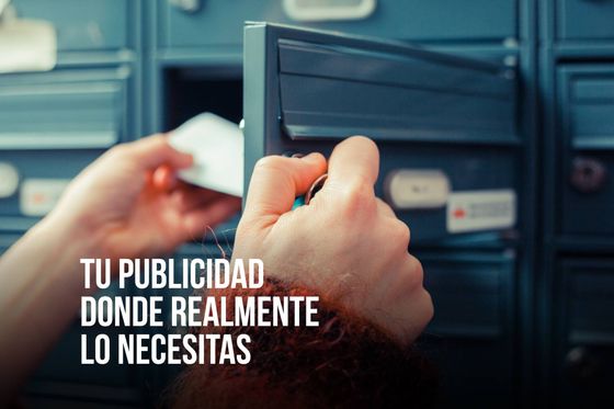 Manos de una persona abriendo un buzón para recoger el correo. Primer plano con buzones azules y un brazo con mangas rojas.