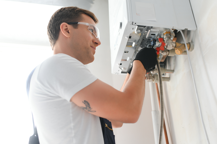 Homme avec des lunettes de protection travaillant sur une chaudière
