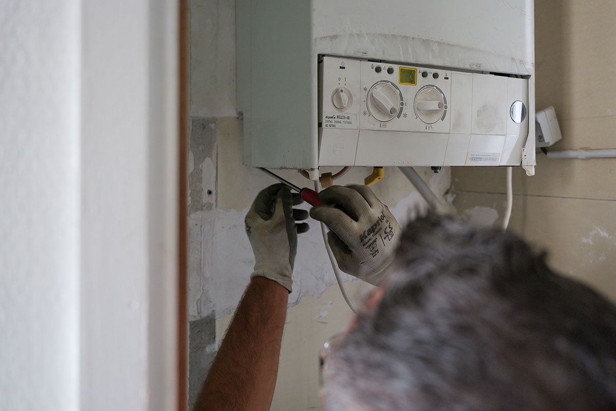 Homme qui répare une chaudière à gaz