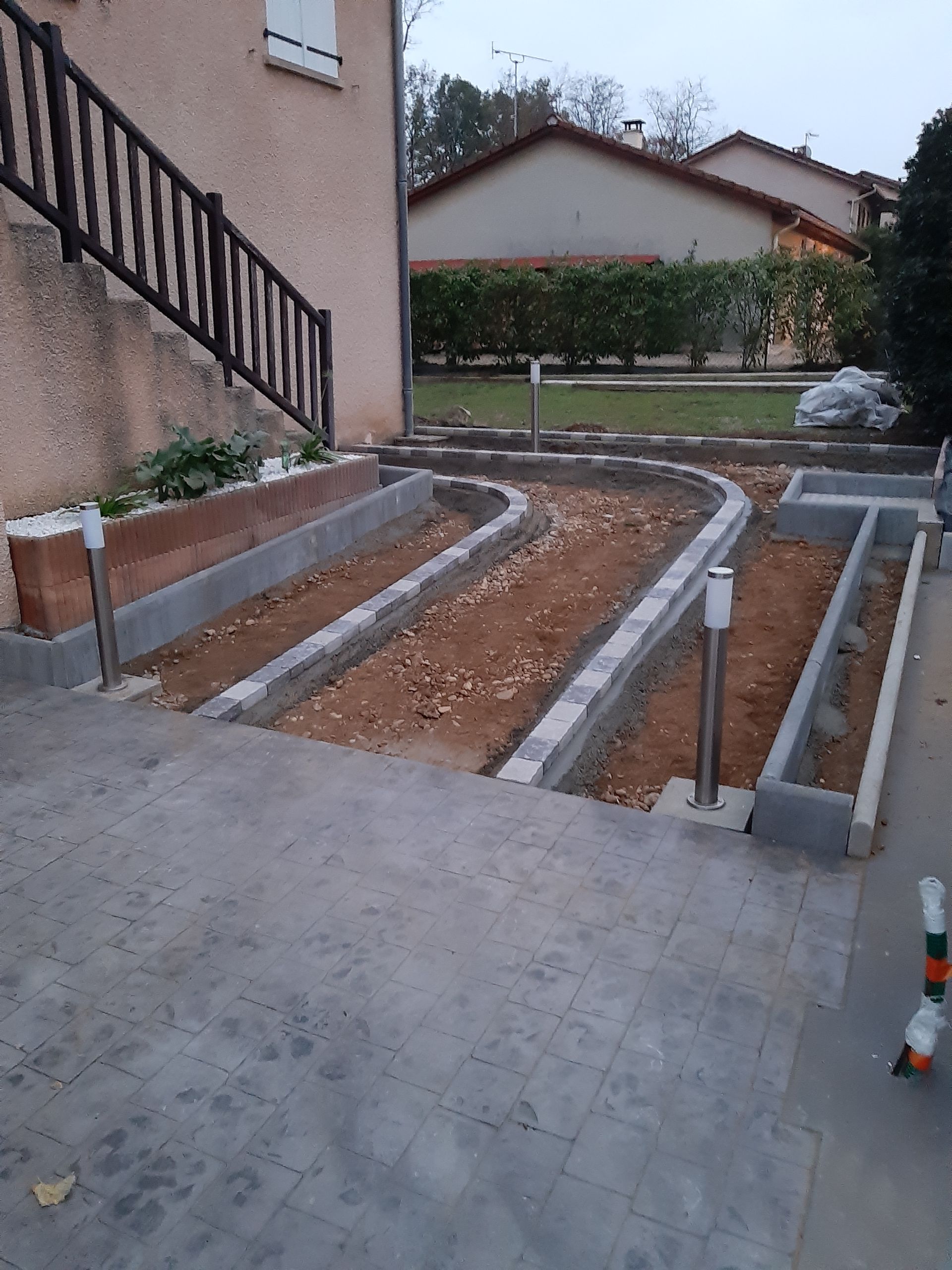 Parpaings pour une construction de dallage au sol à côté d'une maison avec escalier.