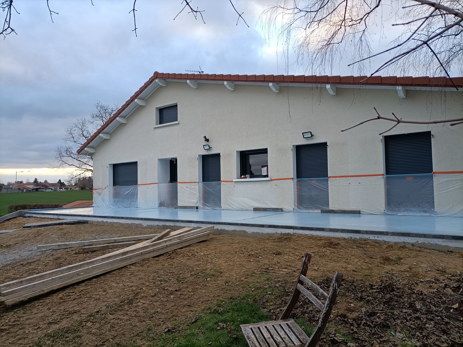 Maison avec terre battue et bâches de protection sur la façade