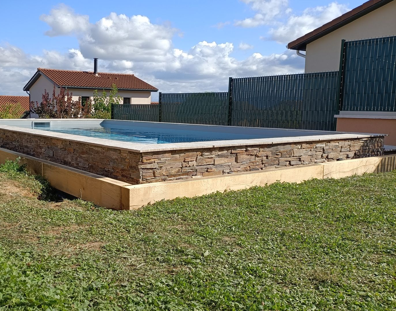 Mur en pierres autour d'une piscine enterrée