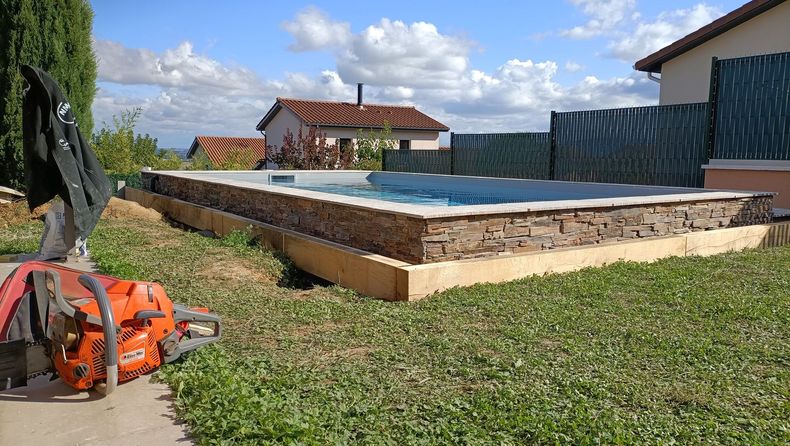 Piscine dans un jardin avec eau bleue, sous un ciel ensoleillé