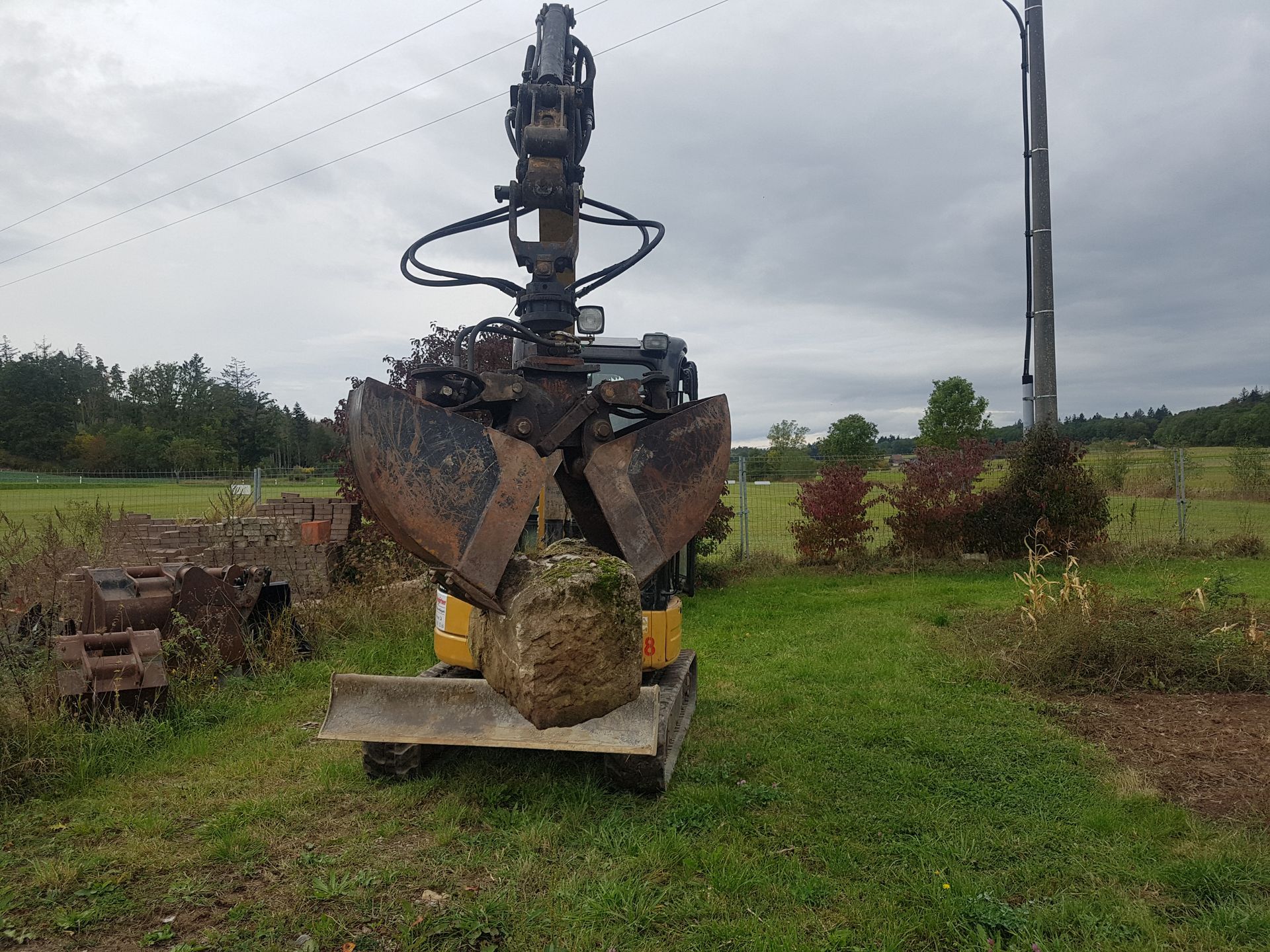Weingärtner Baumaschinen – Bagger mit Zweischalengreifer hebt Steinblock