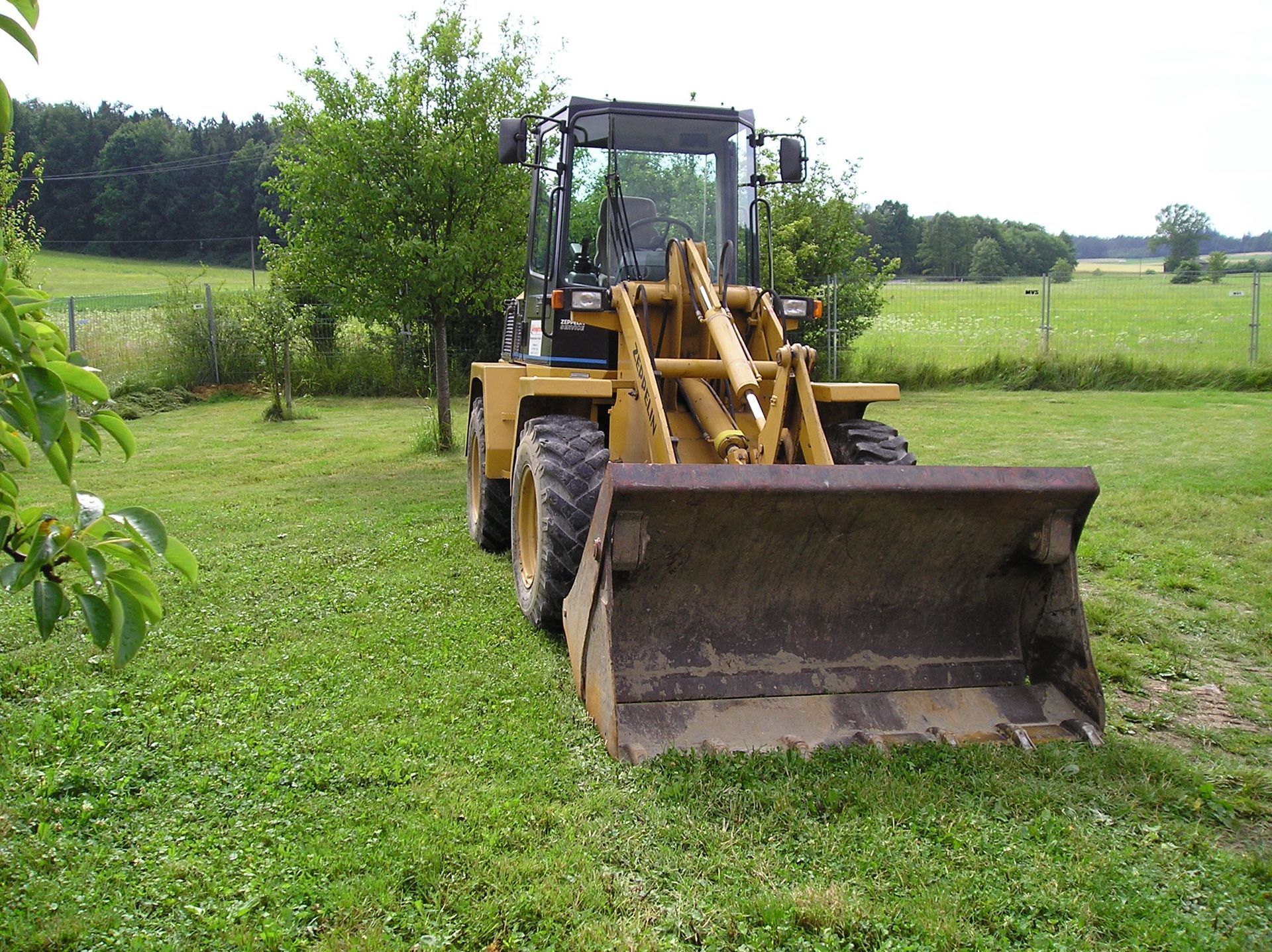 Weingärtner Baumaschinen – Radlader Schaeff SKL 833 auf grüner Wiese geparkt