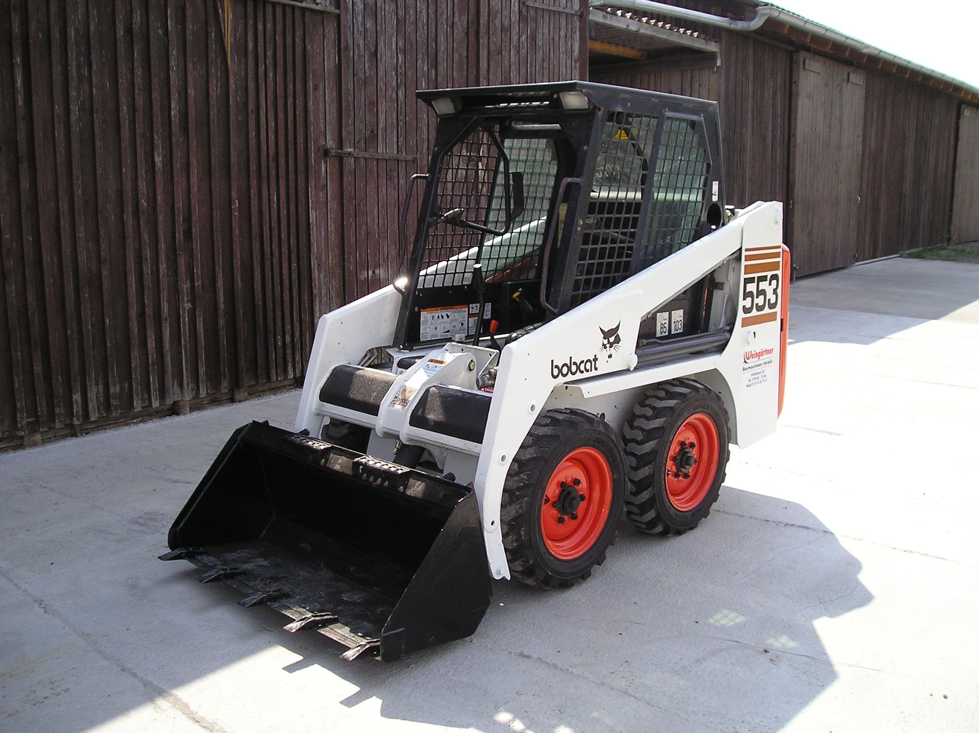 Weingärtner Baumaschinen – Kompaktlader Bobcat 553 auf einem gepflasterten Firmengelände