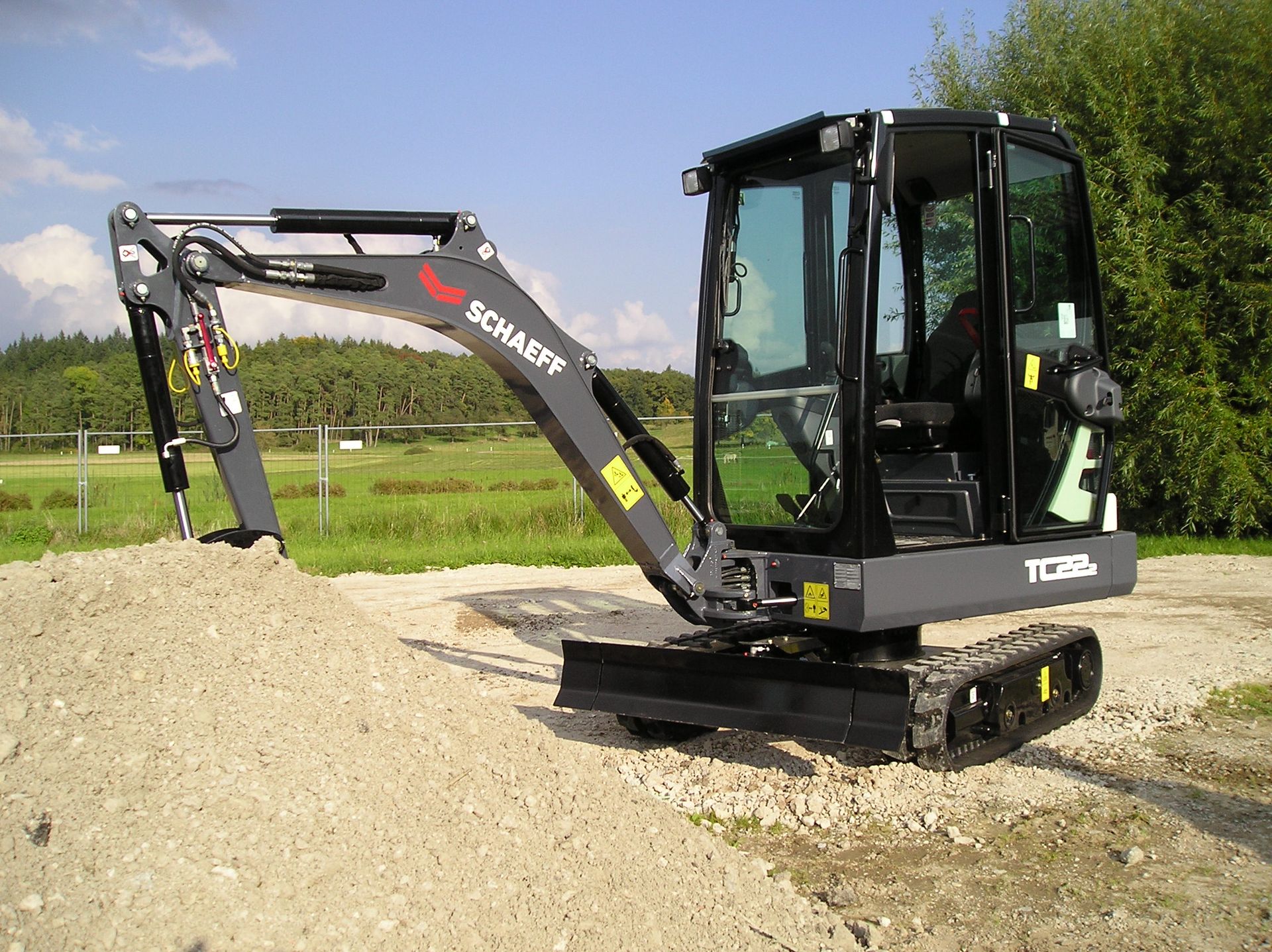 Weingärtner Baumaschinen – Kompaktbagger an einem Kieshügel