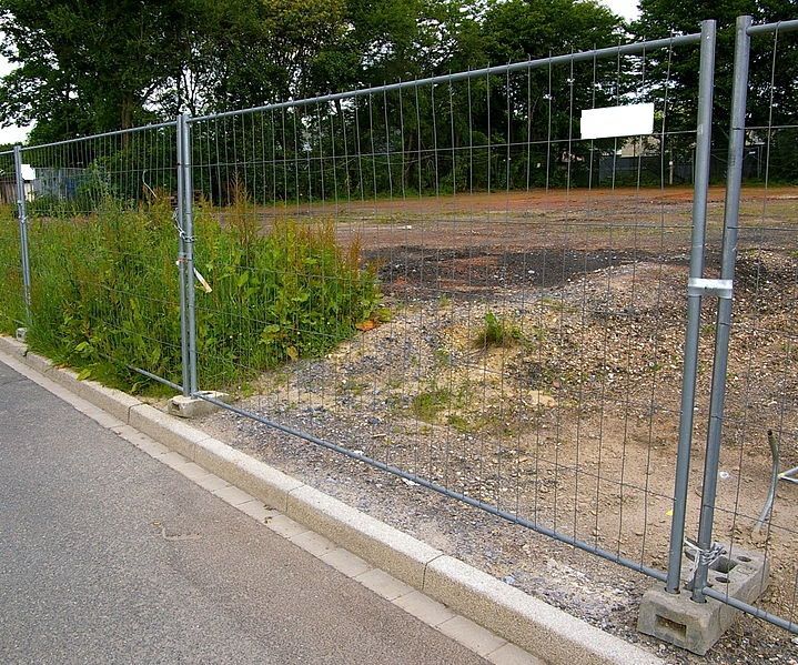 Weingärtner Baumaschinen – Bauzaun an einem Straßenrand versperrt eine Einfahrt